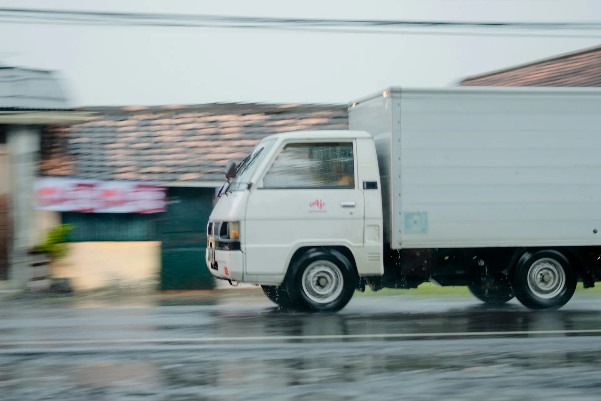 White passenger van travelling on an Indonesian road